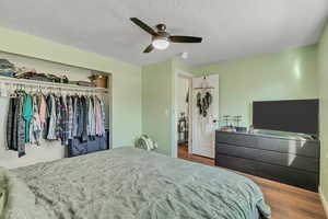 Bedroom with a closet, ceiling fan, and wood finished floors