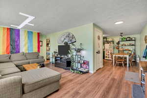 Living area with wood finished floors and a textured ceiling