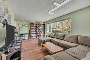 Living area featuring wood finished floors and a textured ceiling