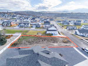 Aerial perspective of suburban area with mountains and property parcel outlined