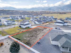 Aerial perspective of suburban area with property boundaries highlighted and a mountain backdrop
