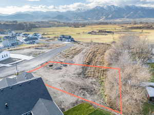 Aerial view of residential area featuring property parcel outlined and a mountain backdrop