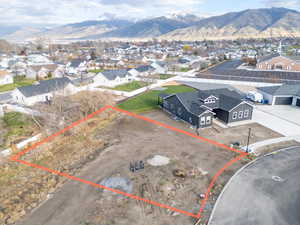 Aerial view of residential area with mountains and property boundaries highlighted