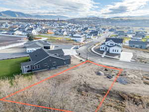 Aerial perspective of suburban area featuring a mountainous background and property parcel outlined