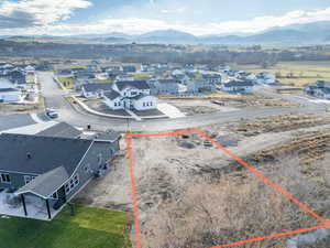 Aerial perspective of suburban area featuring mountains and property parcel outlined