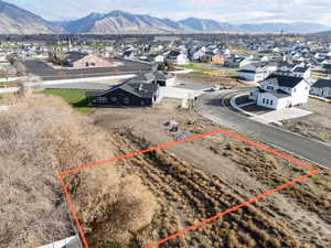Aerial view of residential area featuring property boundaries highlighted and mountains
