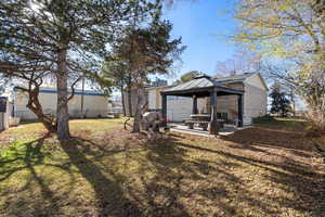 Rear view of house with a patio, a gazebo, and brick siding