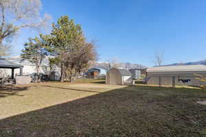 Fenced backyard with a storage unit, a mountain view, a gazebo, and a patio area