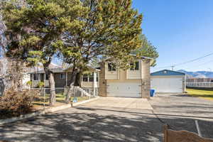 Tri-level home with brick siding, driveway, and a mountain view