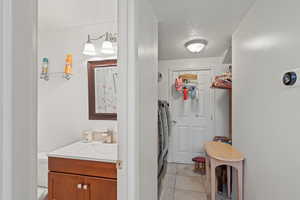 Bathroom with vanity, curtained shower, a textured ceiling, and light tile patterned flooring