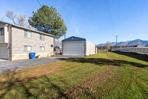 Rear view of house with a detached garage, an outbuilding, brick siding, and a mountain view