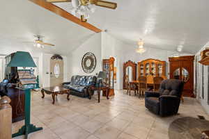 Living area featuring light tile patterned floors, a ceiling fan, a textured ceiling, high vaulted ceiling, and beamed ceiling