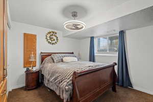 Bedroom with a textured ceiling and dark carpet