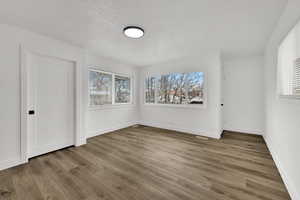 Spare room with a textured ceiling and light wood finished floors