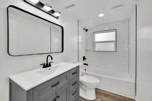 Bathroom with vanity, bathtub / shower combination, light wood finished floors, and recessed lighting