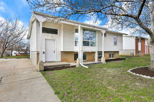 View of front of home with a front yard and brick siding