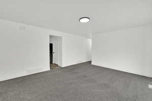 Carpeted spare room with baseboards