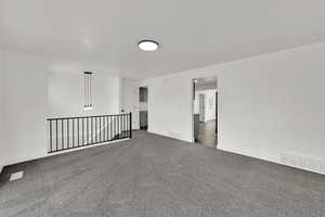 Carpeted spare room featuring baseboards