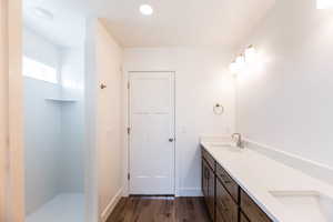 Photo of home built in past by OLO. Full bath featuring double vanity, dark wood-style floors, and walk in shower