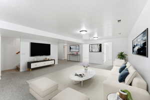 Virtually staged family room down featuring light colored carpet and stairs