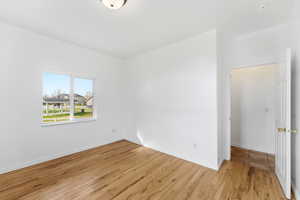 Spare room featuring light wood-style flooring and baseboards