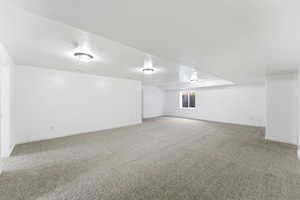 Empty room featuring light colored carpet and baseboards