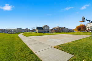View of basketball court featuring a lawn, a residential view, and community basketball court