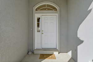 Doorway to property featuring stucco siding