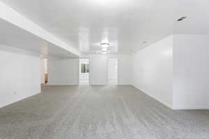 Family room with light carpet and a textured ceiling, new carpet and paint.