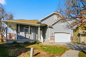 View of front of home with driveway, a porch, stucco siding, a shingled roof, and a front yard