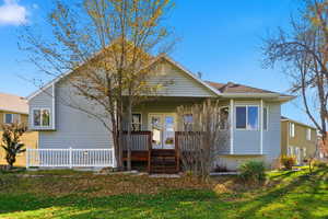 Back of house featuring a yard and a wooden deck