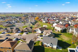 Aerial view of property and surrounding area featuring nearby suburban area