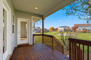 Wooden porch featuring a residential view and a yard