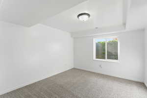 Spare room featuring carpet and baseboards