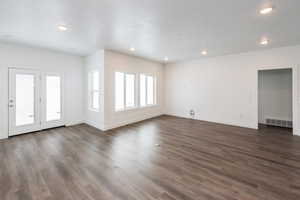 Photo of home built in past by OLO. Unfurnished living room with dark wood-style floors and recessed lighting