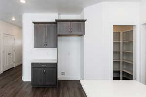 Photo of home built in past by OLO. Kitchen with light countertops, dark brown cabinets, dark wood finished floors, and recessed lighting