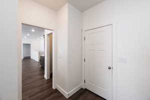 Hall with dark wood-style floors and baseboards