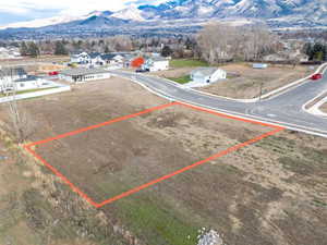 Aerial view of property and surrounding area with mountains and property parcel outlined