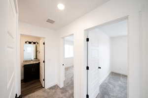 Corridor with light carpet and recessed lighting