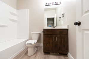 Bathroom with vanity, light wood-style floors, and tub / shower combination