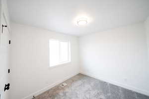 Carpeted spare room with baseboards
