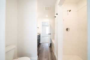 Bathroom featuring vanity, dark wood-style flooring, a shower, and a tub