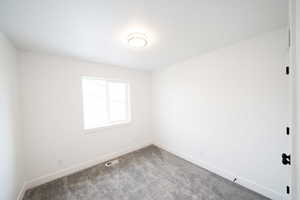 Spare room with baseboards and carpet