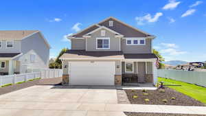 Craftsman house featuring board and batten siding, stone siding, driveway, a garage, and a shingled roof