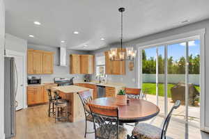 Kitchen with light countertops, light wood-style floors, a chandelier, appliances with stainless steel finishes, and recessed lighting