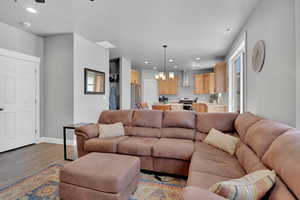 Living room featuring a chandelier, recessed lighting, light wood-style flooring, and plenty of natural light