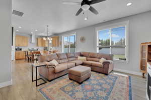 Living area with recessed lighting, a chandelier, healthy amount of natural light, a ceiling fan, and light wood-style flooring