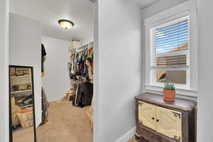 Walk in closet featuring light carpet