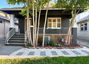 Entrance to property with a porch and brick siding