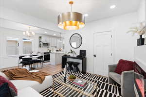 Living room with recessed lighting, light wood-style flooring, and a chandelier